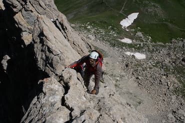 Alpiniste escaladant une paroi vertigineuse dans les Pyrénées catalanes.